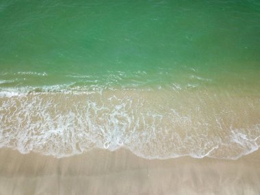 Temiz kumsalda mavi okyanus dalgası. Tatiller ve Seyahat Konsepti