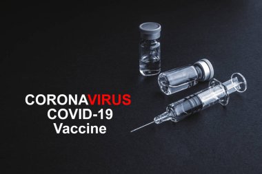 CORONAVIRUS COVID-19 VACCINE metin üzerinde şırınga ve şişeler siyah arka planda. Covid-19 ve Coronavirus konsepti