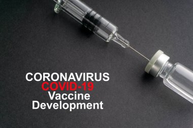 CORONAVIRUS COVID-19 VACCINE DEVELOPMENT metin ve siyah arka planda şırınga ve şişeler. Covid-19 ve Coronavirus konsepti