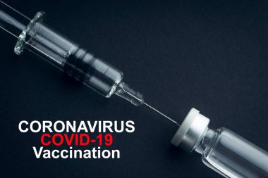 CORONAVIRUS COVID-19 VACCINATION metin üzerinde şırınga ve şişeler siyah arka planda. Covid-19 ve Coronavirus konsepti