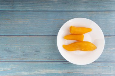 Ubi rebus ya da buharlı cassava, ahşap arka planda bulunan geleneksel Malay tabağıdır. Seçici odak