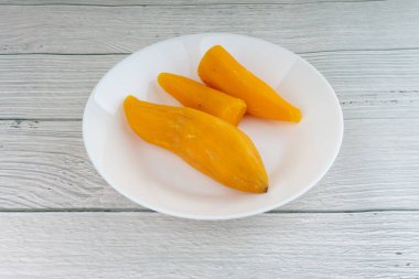 Ubi rebus ya da buharlı cassava, ahşap arka planda bulunan geleneksel Malay tabağıdır. Seçici odak