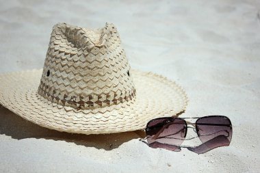 Tropik bir plajda hasır şapka ve güneş gözlüğü. Metin için yeri olan yaz aksesuarları.