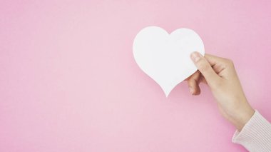 Kalp şekli kartı tutan el