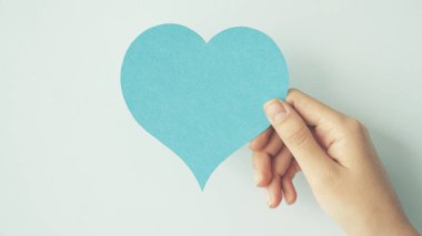 Kalp şekli kartı tutan el