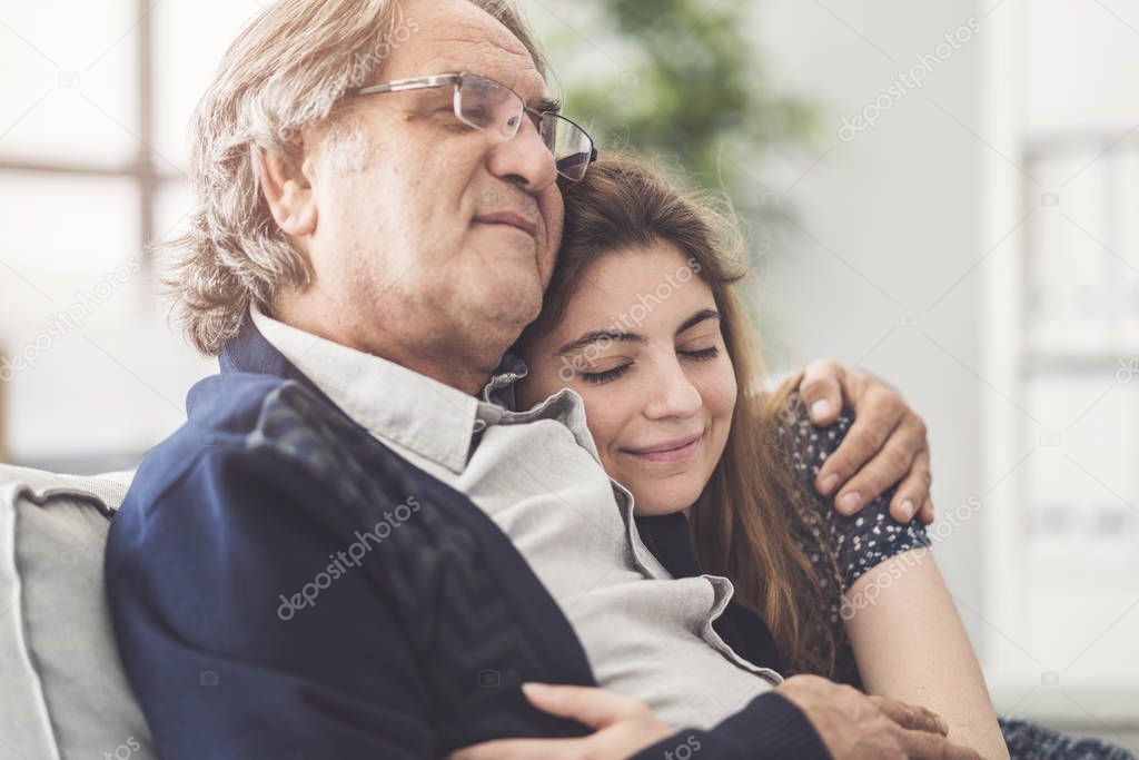 Young daughter hugs her father