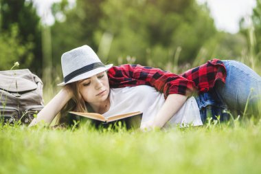 Kız yalan ve çimlerin üzerine kitap okuma