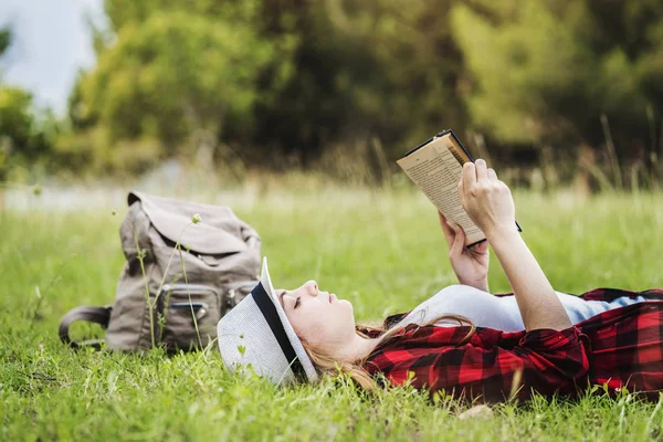 Kız yalan ve çimlerin üzerine kitap okuma