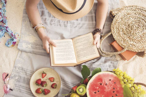 Kız plaj havlusu üzerinde okuma