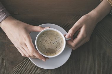 Bir fincan kahve elinde
