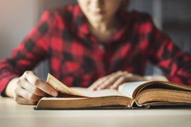 Genç kadın kitap okuyor. 