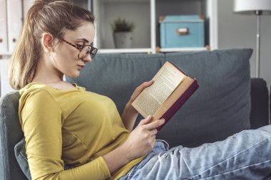 Genç kadın kitap okuyor. 