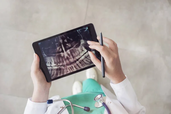 Doctor looking at teeth X-ray on digital tablet