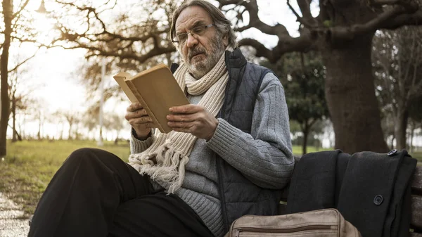 老人は 公園で本を読んで — ストック写真