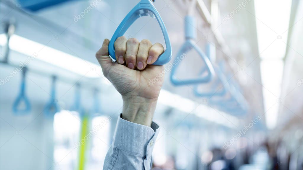 Man hand holding handle on the train