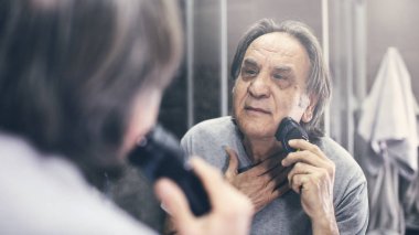 Olgun adam ayna önünde tıraş