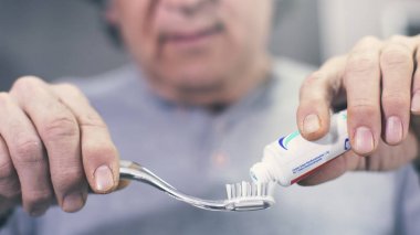 Adam bir diş fırçası üzerinde bir tüp bir diş macunu çıkarma