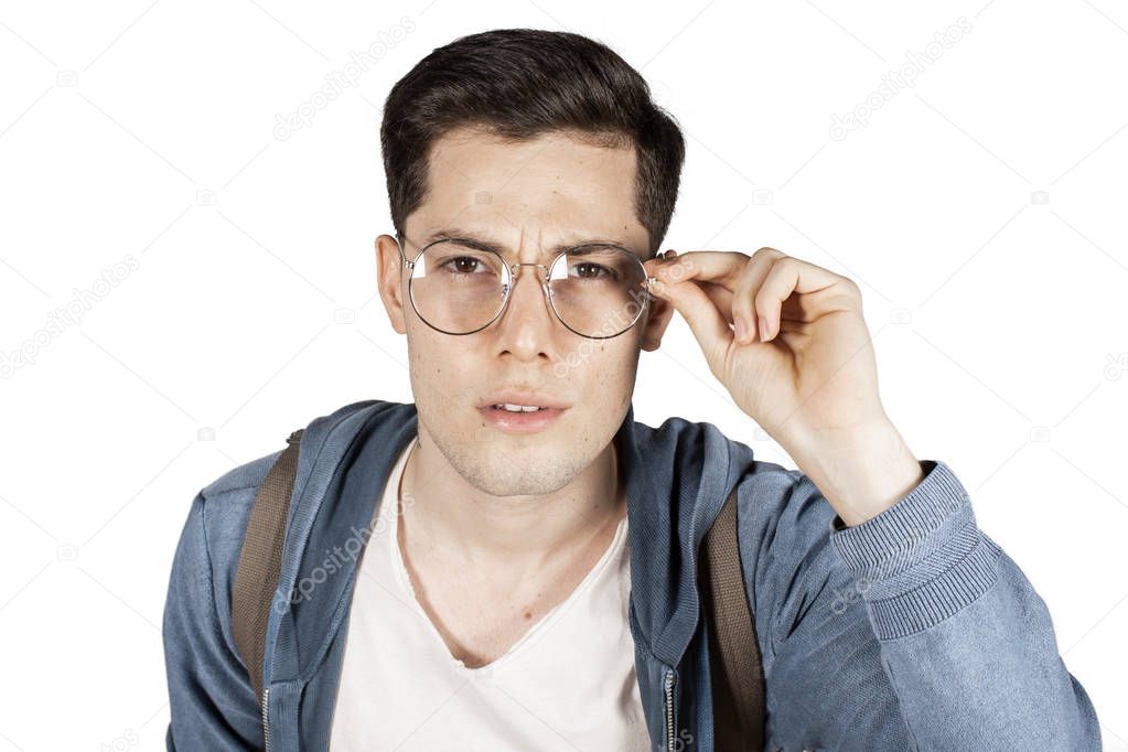 Young man looking over glasses curiously