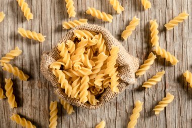 Tahta arka planda çuvalda makarna