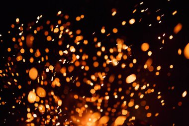 Siyah bir arka planda yangın kıvılcımları.