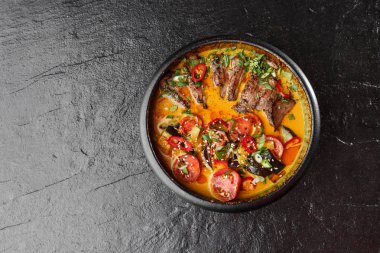 Kaeng Ped Yang rostosu ördek, kırmızı körili, pirinçli. Tayland mutfağı. Restoran, öğle yemeği, akşam yemeği. Yukarıdan bak. siyah taş arkaplan