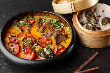 Kaeng Ped Yang rostosu ördek, kırmızı körili, pirinçli. Tayland mutfağı. Restoran, öğle yemeği, akşam yemeği. Yukarıdan bak. siyah taş arkaplan