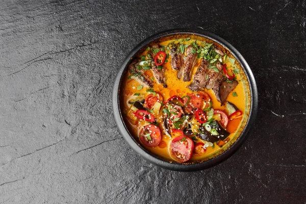 Kaeng Ped Yang rostosu ördek, kırmızı körili, pirinçli. Tayland mutfağı. Restoran, öğle yemeği, akşam yemeği. Yukarıdan bak. siyah taş arkaplan