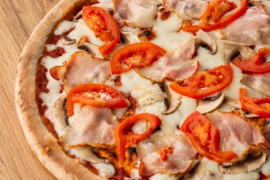 İtalyan lezzetli taze sıcak Mix pişmiş pizza eritme peyniri, dilimlenmiş mantar, jambon, domates sosu ve dokulu rustik arka planda hizmet çedar. üst görünüm.