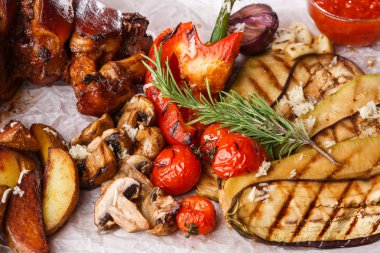 Izgara domates, champignons, vagetable ilik, patlıcan, kırmızı tatlı biber ve pişmiş patates ve parşömen ahşap kesme tahtası ile ızgara domuz eklem. üst görünüm