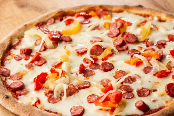 Biber, sıcak sosis, soğan, domates ve peynir ile sıcak pizza üst görünümü. 
