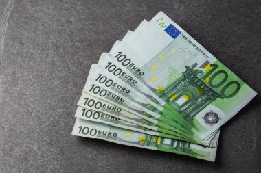 Euro banknotları kapanıyor. Gri üzerine birkaç yüz avroluk banknot.