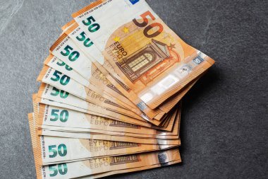 Euro banknotları kapanıyor. Gri arka planda birkaç 50 Euro 'luk banknot.
