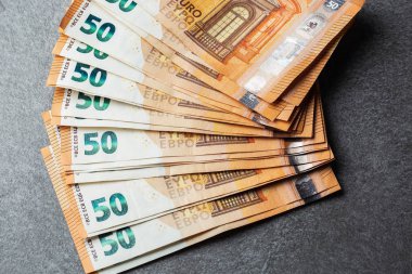 Euro banknotları kapanıyor. Gri arka planda birkaç 50 Euro 'luk banknot.
