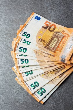 Euro banknotları kapanıyor. Gri arka planda birkaç 50 Euro 'luk banknot.