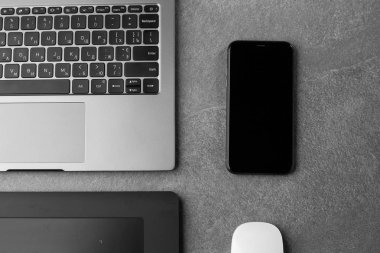 Üzerinde siyah ekran, fare, grafiksel tablet ve modern gri taş masadaki akıllı telefon, masanın üzerinde açılı defter, not defteri ve bilgisayar olan ofis masası olan iş yeri. kopyalama alanı. yatay