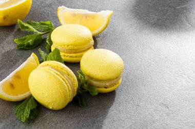 Fransız kurabiyeleri izole edilmiş. Seçici odaklanma. Limonlu ve nane arkaplanlı güzel sarı badem kurabiyeleri. Güzel bir düzenleme. Düz yerde, üst tarafta. Makro fotoğraf.