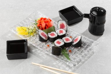 Şeffaf tabakta servis edilen ton balıklı Maki suşi ruloları. Lezzetli geleneksel Japon yemekleri, lezzetli deniz ürünleri, restoran konsepti, yemek geçmişi. yatay resim