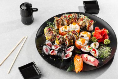 Japon suşi seti. Taze ton balığı maki, somon nigiri ve siyah tabakta servis edilen ejderha suşi ruloları. Üst görünümün yatay üst görüntüsü düz yatıyordu. Büyük bir şirket için bir set..