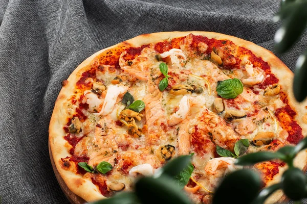 Pizza italiana de mariscos con camarones, calamares, mejillones, hierbas frescas y mozzarella sobre una base crujiente vista desde arriba sobre fondo gris. Fotografía horizontal . — Foto de Stock