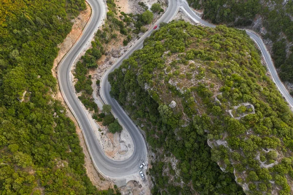 Vue de dessus de la route serpentine au milieu de la forêt verte. Incroyable paysage naturel. Vue aérienne depuis un drone volant. arbres verts d'été et route dans la forêt. Photo horizontale . — Photo