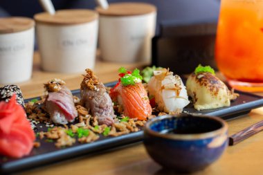Şeffaf tabakta servis edilen somon, yılan balığı, ton balığı ve karidesli Nigiri suşisi. Lezzetli geleneksel Japon yemekleri, lezzetli deniz ürünleri, restoran konsepti, yemek geçmişi..
