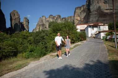 En tepesinde Ortodoks manastırları olan dikey uçurumları olan eşsiz jeolojik manzara fenomenine sahip güzel bir çift. Doğanın mucizesi.