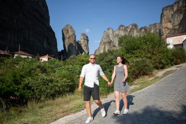 En tepesinde Ortodoks manastırları olan dikey uçurumları olan eşsiz jeolojik manzara fenomenine sahip güzel bir çift. Doğanın mucizesi.