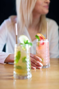 İki bardak çilekli ve limon ve naneli klasik mojito kokteyli, soğuk, ferahlatıcı içecek ya da parlak arka planda buzlu içecek. Genel görünüm, kopyalama alanı. Kafe menüsü reklamı