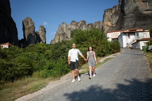 Krásný pár na unikátním geologickém fenoménu krajiny s obrovskými svislými útesy, na jejichž vrcholu jsou ortodoxní kláštery. To je zázrak přírody. — Stock fotografie