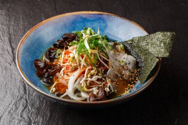 Asya usulü vejetaryen erişte çorbası, tofu, kimchi, sebze ve mantarlı erişte çorbası. Geçmişi sil. Üst Manzara. Bir kase Asya usulü çorba. Japon mutfağı. Üst Manzara. Pankart. Asya yemekleri