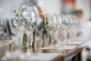 Lüks bir düğündeki masalar. Misafirler için bir masa. Tabaklar ve içecekler. Çiçek süsleme, beyaz sandalyeler ve masa. Düğün masası hazırlığı. Üst Manzara. Yatay fotoğraf