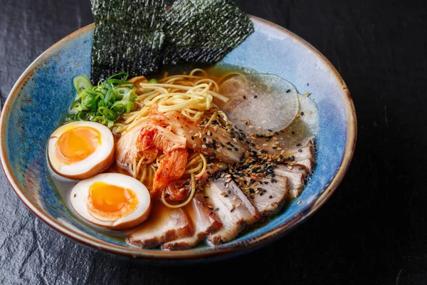 Aziatische noedelsoep, ramen met varkensvlees, tofu, kimchi, groenten en ei in blauwe kom. Lage achtergrond. Bovenaanzicht. Bowl van Aziatische stijl soep. Japanse keuken. Bovenaanzicht. Een spandoek. Aziatische levensmiddelen — Stockfoto