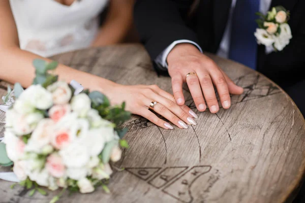 Image parfaite avec espace de copie pour les magazines de mariage et les sites Web, bohème, mode, fleuriste. Copiez l'espace. Couple assis, étreignant et montrant des bagues près du bouquet de mariage . — Photo