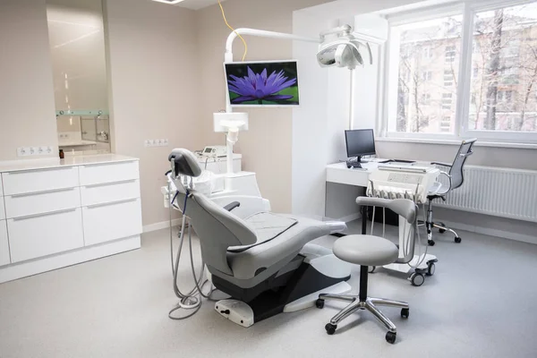 Modern Diş Kliniği, dişçi koltuğu ve diş hekimlerinin kullandığı diğer aksesuarlar. Diş cerrahı, bir cerrah. Dişçinin ofisi. Modern ve temiz iç mekanlarda diş donanımı